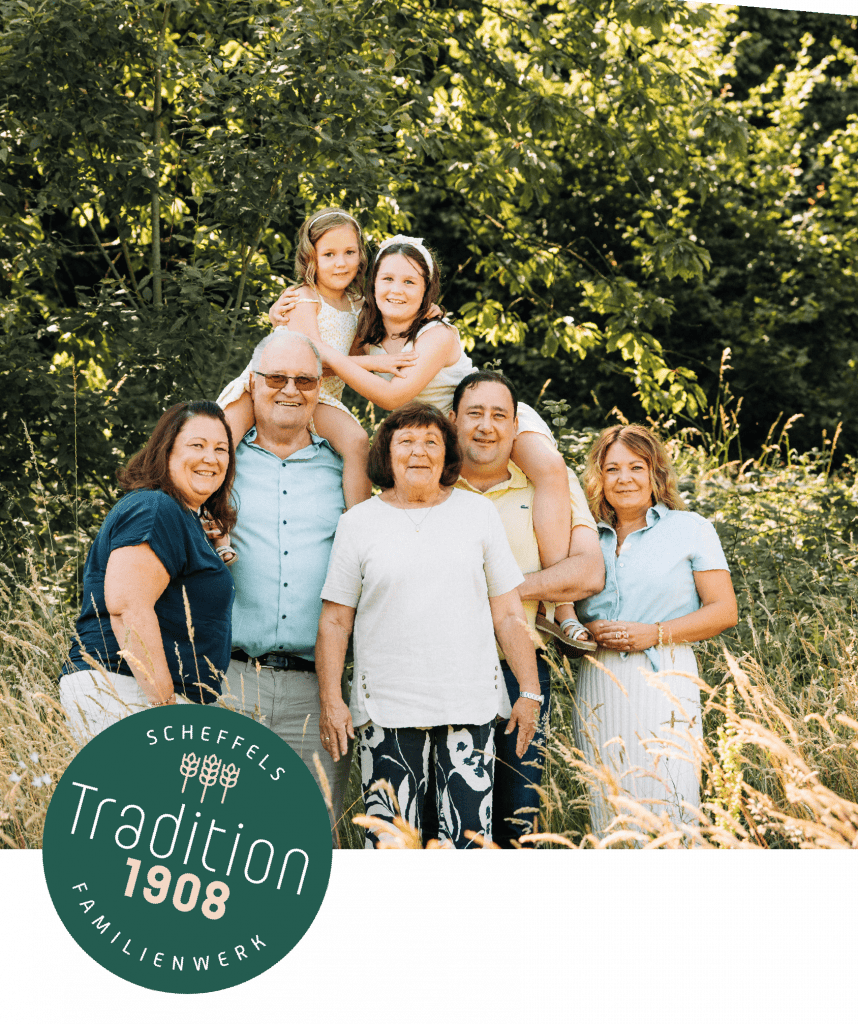 ein Bild der Familie Scheffel in einer Wald und Feld Kulisse. Auf der linken Seite befindet sich ein Grüner Kreis mit der Aufschrift Scheffels Familienwerk – Tradition 1908
